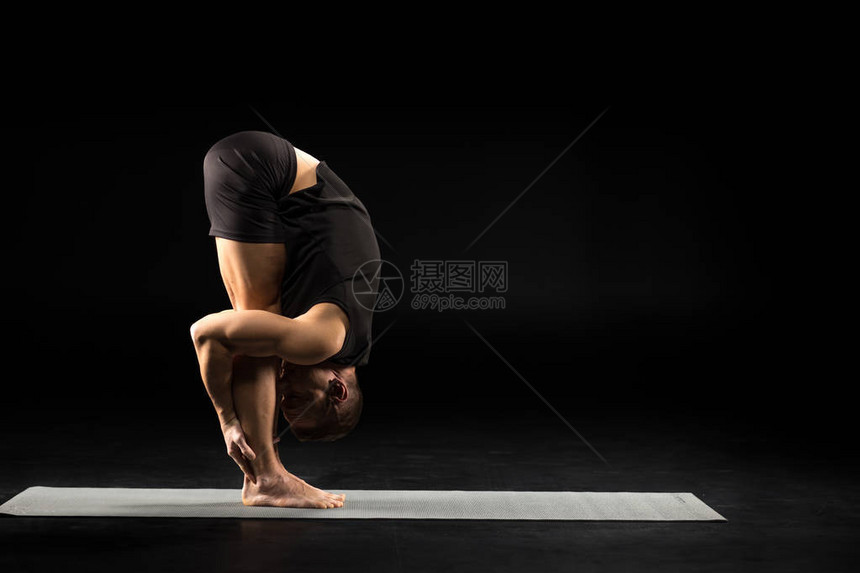 员在Uttanasana或站立前弯姿势练习瑜伽的侧视图片