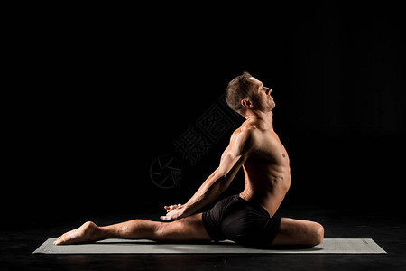 年青男子练瑜伽表演鸽子在隔离在黑边的瑜伽图片