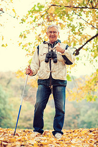 秋天快乐的老人在森林里徒步旅行图像是图片