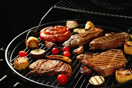 烧烤炉排上的新鲜烤肉牛排和蔬菜图片