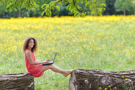 年轻女子在大自然中使用笔记本电脑图片