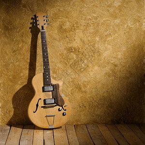 老墙上的老式爵士吉他图片