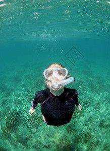 带着呼吸管和潜水面罩在海洋水下浮潜的女人图片