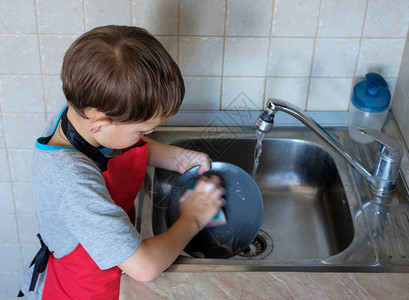 男孩七岁在家洗盘子图片