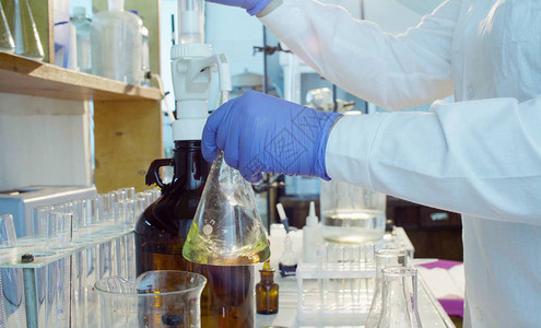 化学分析实验室紧握科学家钻孔溶液的手背景图片