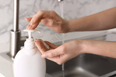 用液体肥皂洗手的女人图片