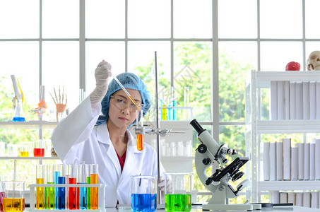 实验室的女科学家用试管中的滴管合成化合物进行实验医疗保健技术和药物研图片