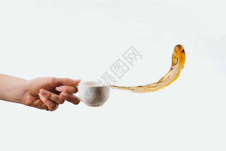 手握白色杯子并喷洒芳香咖啡孤立在图片