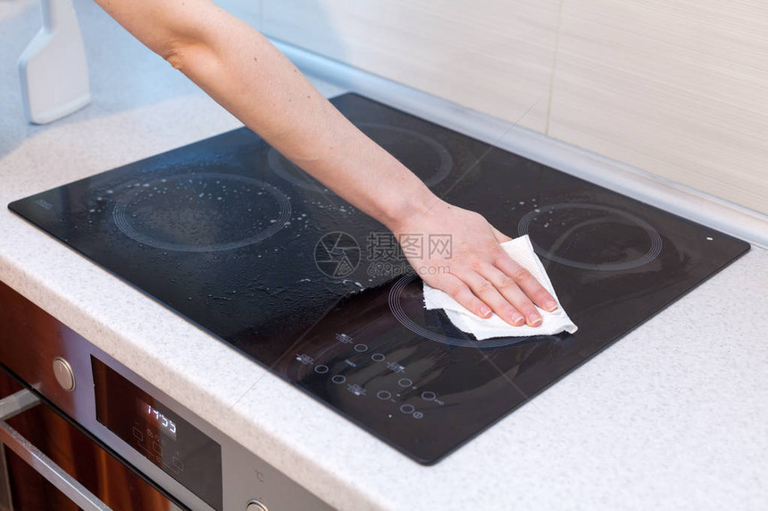 家庭主妇打扫和擦洗电动炊具厨房顶部黑光的表面图片