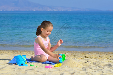 真正可爱的蹒跚学步的女孩在沙滩高清图片