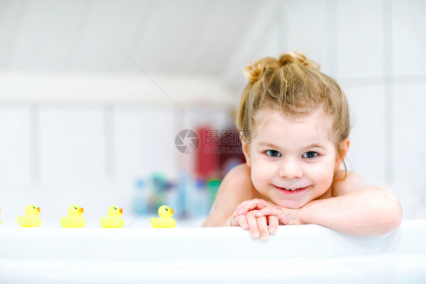 快乐健康的宝贝孩子玩黄色橡胶口香糖玩具鸭子图片