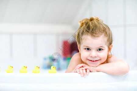 快乐健康的宝贝孩子玩黄色橡胶口香糖玩具鸭子图片