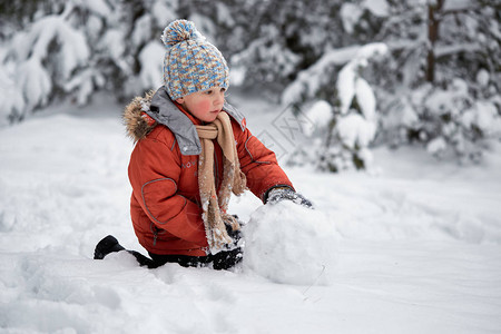 冬天的乐趣男孩雕刻雪人图片