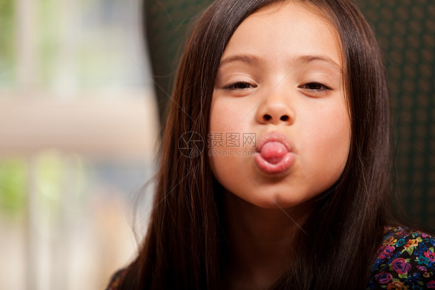 小女孩伸出舌头坐在扶手图片