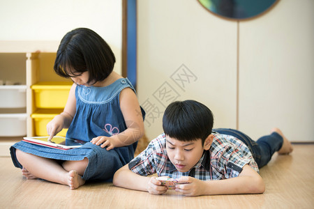 亚裔小男孩与女孩一起玩电脑图片