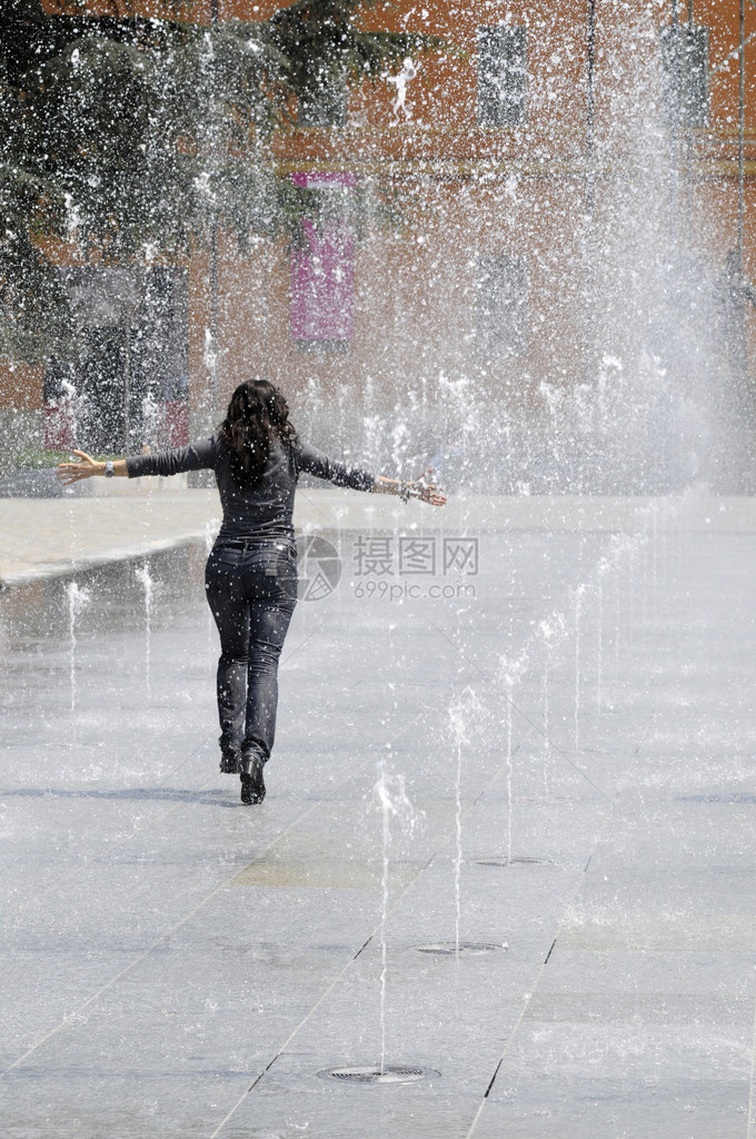 夏天在意大利广场的喷泉水下跑来去的年轻女图片