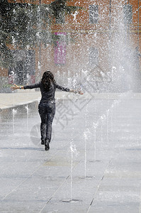 夏天在意大利广场的喷泉水下跑来去的年轻女图片