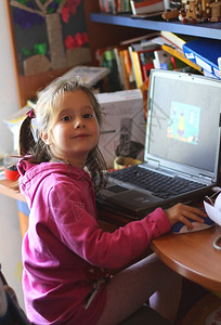 小孩在卧室里学习使用电脑图片