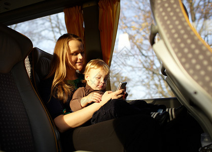 年轻母亲在乘公车旅行时图片