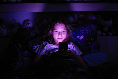 小女孩躺在黑暗中在一张毯子下图片