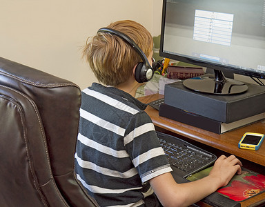 在电脑上玩电子游戏时戴着耳机的草莓金图片