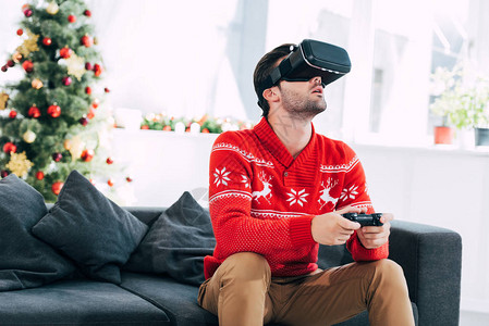 在圣诞节前夕玩电子游戏的虚拟现实头耳图片