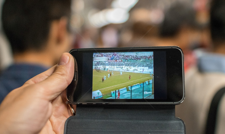 在地铁列车的手机上观看足球比赛校对P图片