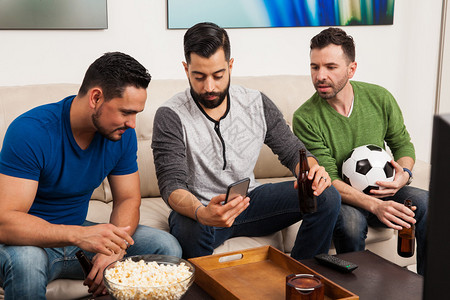 一群朋友一边在电视上观看足球比赛图片