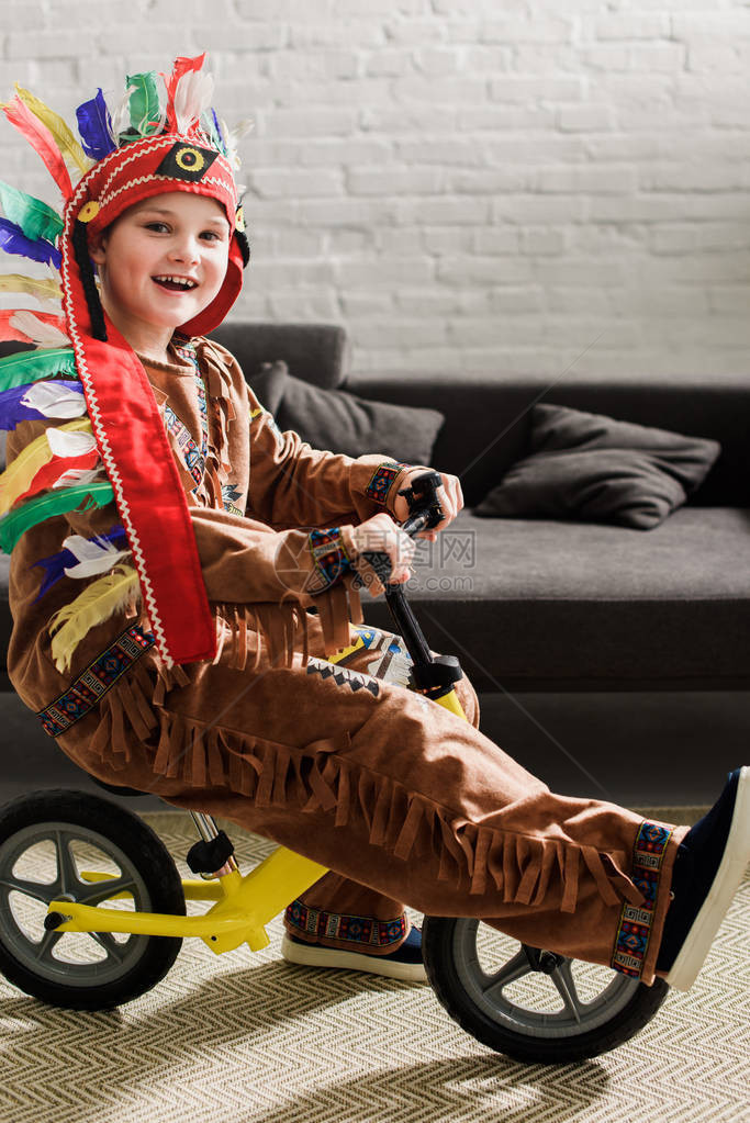 穿着土著装扮的快乐小男孩骑图片