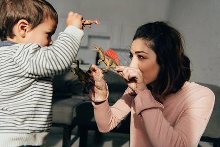 母亲和小儿子在家客厅玩具恐龙图片