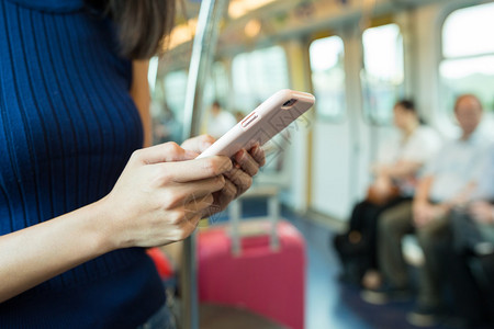 在火车厢内使用手机的女人图片