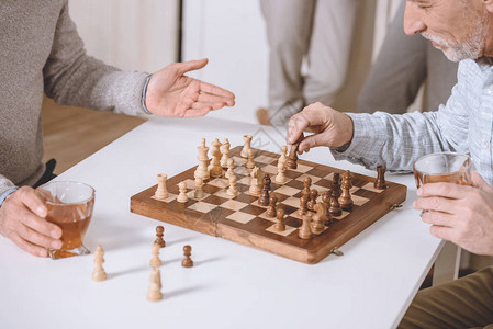 男人坐在桌边下棋打象图片