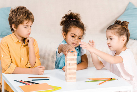 多种族可爱的孩子用木块在桌子图片