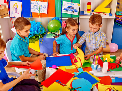 一大群孩子在学校的桌子上用彩色纸做小学儿童的教育儿童和图片