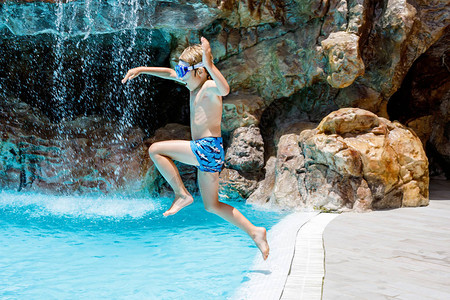 快乐的小男孩跳进游泳池图片
