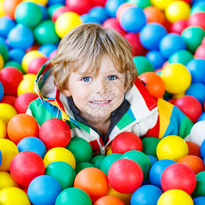 快乐的小男孩在多姿彩的塑料球操场玩耍可爱的孩子在图片