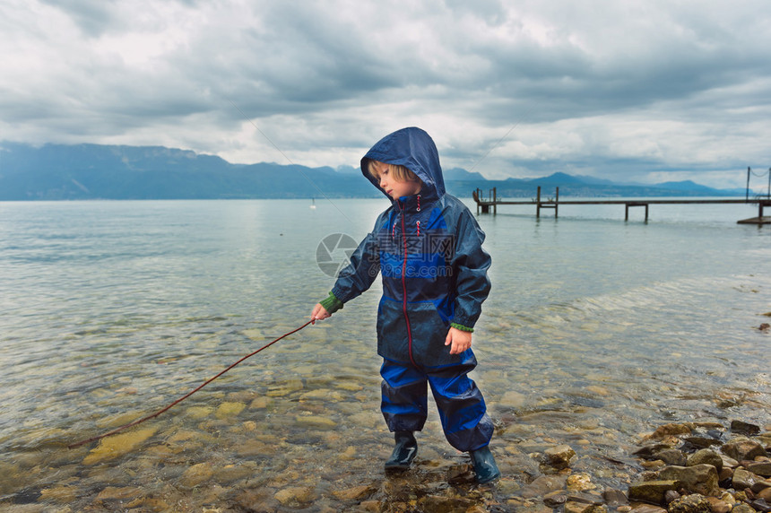 小可爱男孩在湖边玩耍假装钓鱼穿着蓝水衣全对图片