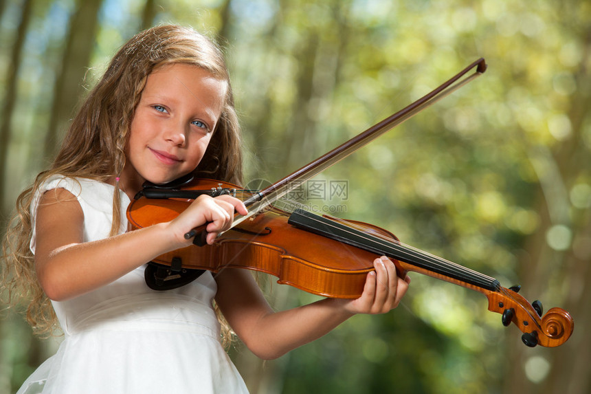 在户外玩小提琴的白人女孩图片