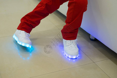 小男孩穿着发光的白色LED运动鞋带灯的鞋子图片