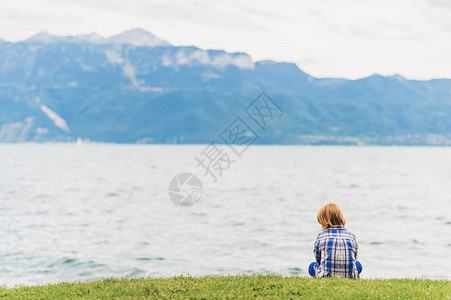 小男孩在阴天在湖边玩耍图片