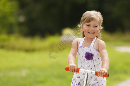 小女孩在公园里骑摩托车图片