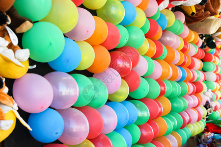 墙上装有不同颜色的气球用来在集市上玩飞镖投球游戏背景图片