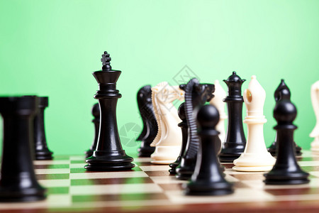 棋子在船上专注于黑国王绿色背景图片