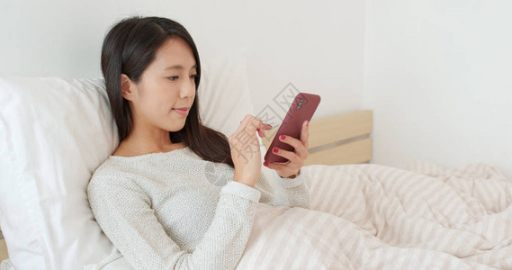 女人在床上用手机图片