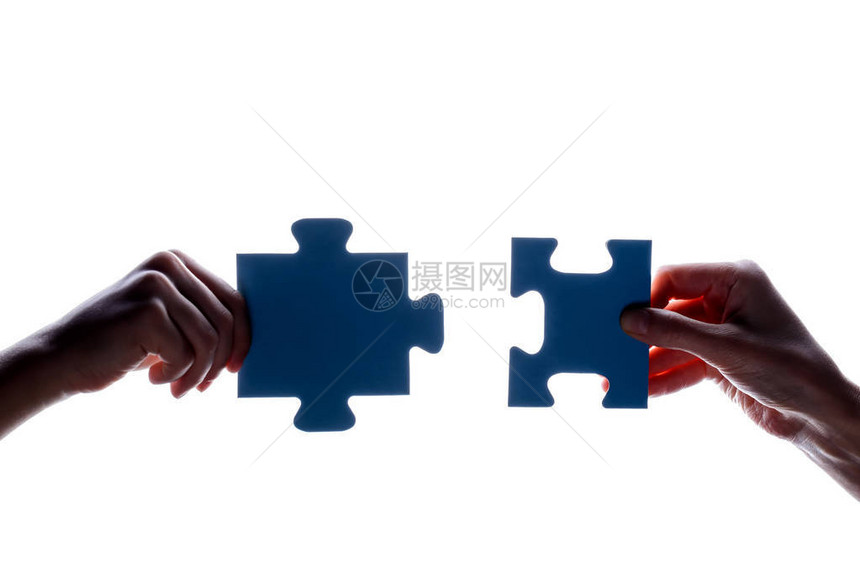 两只手拿着几块蓝色拼图块在白色背景上的剪影概念连接想法标志符号友谊图片