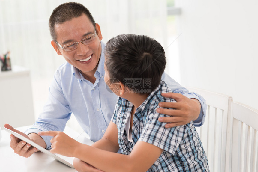 亚洲父亲和儿子在说话和使用图片