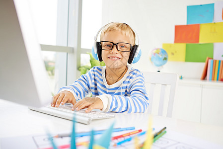 戴眼镜玩电脑的快乐男孩图片