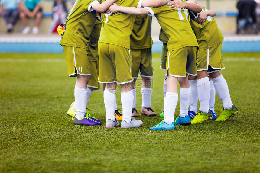 穿着黄色运动服的年轻足球运动员球场上的年轻运动队决赛前的鼓舞人心的谈话足球学校锦标赛运动图片