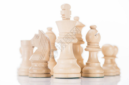 白色木制国际象棋国王与骑士和主教在白色两侧背景图片