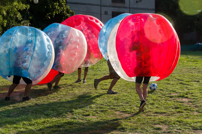 青少年在BubbleBumb新而有趣的户外团队游戏中玩耍孩子们都生活在被吹散的塑料透明泡沫内图片
